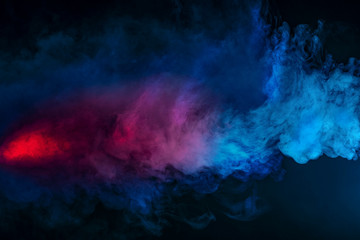 Abstract texture of backlit smoke in red blue on a black background.