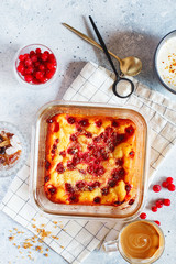 Cottage cheese casserole baked with red currants. Curd casserole with fresh berries on kitchen table.