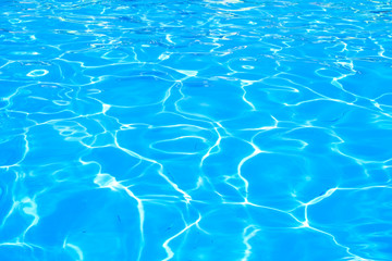 Surface of blue swimming pool. Background of water in swimming pool. Shining blue water ripple background. 
