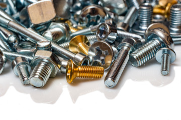 Bolts and screws from steel and bronze on a white background.