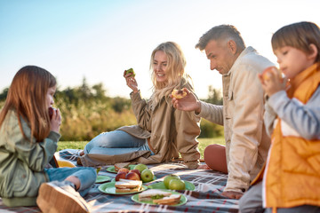 Eating outdoors. Happy family spending time in the park on a sunny day