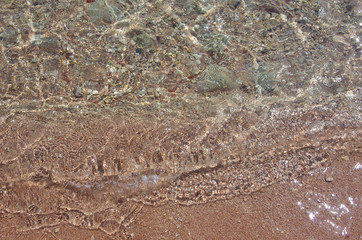 Background of the seabed. Sea stones, clear water and beautiful glare. Seaside