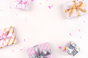Several gift boxes with bows and confetti on a white background. Flat lay composition. Birthday, christmas, wedding or another holiday concept.