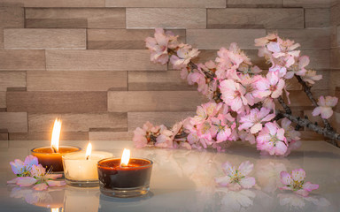 Ambiance relaxante et zen avec bougies et branche d'amandier en fleur.