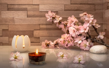 Ambiance relaxante et zen avec bougies et branche d'amandier en fleur.