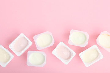 Tasty yogurt in a plastic glass on a colored table top view. Place to insert text. Useful snack.