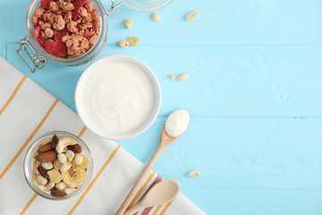 Yogurt with fruits, granola and nuts on the table top view. Healthy breakfast, natural yogurt.