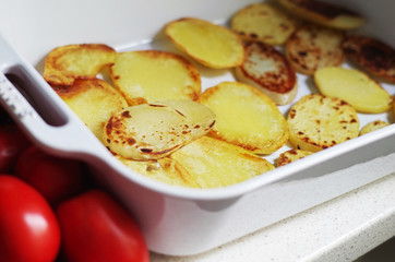 Layer of sliced fried potato prepared for baking greek traditional cuisine - moussaka. Cooking sequence.