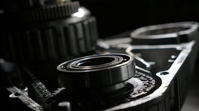 Polished ball-bearing and cogwheels with teeth rotating fast in car gearbox