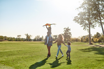Love makes a family. Happy family playing a kite. Outdoor family weekend