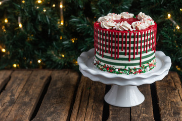 White and green striped buttercream christmas with red drip cake view from side