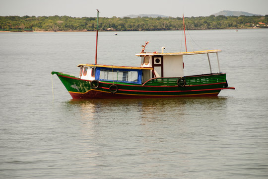 hing boats anchored in the river, floating peacefully in harbor.