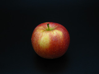 red and yellow apple on dark background
