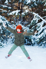 Little girl jumping in snowy forest.