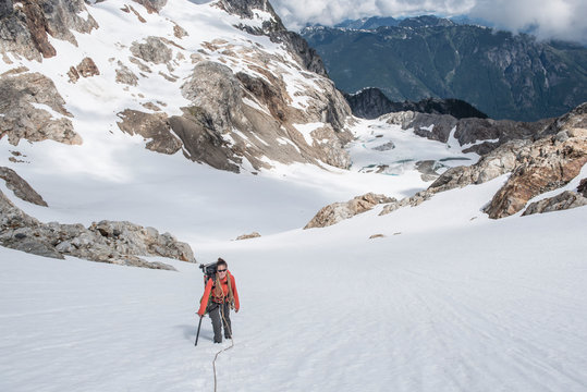 A woman climbs a glacier on Snowfield Peak in the North Cascades
