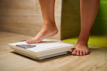 Feet of a woman on a weight scale while weighing