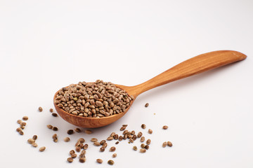 Hemp seeds in wooden spoon, isolated.