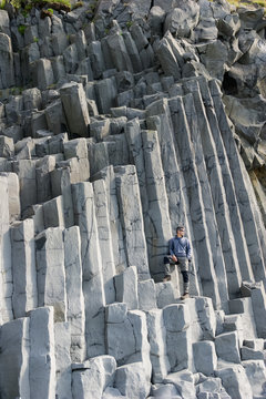 Man posing in the columns of the Reynisdrangar on Reynisdrangar beach