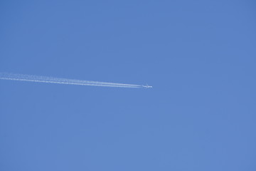 clear blue sky with random traces of burned fuel from the plane on a clear Sunny day.
