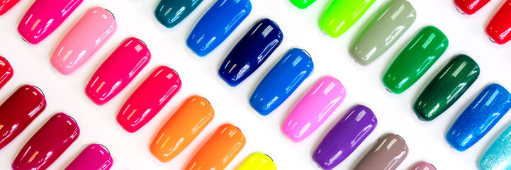 Multicolored nail Polish samples on a white background. Beauty banner. Trendy open composition, pattern. Nail varnish. Top view, flat lay, layout. Fashion, style. Summer manicure. Cosmetic products.