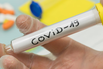 COVID-19 / Coronavirus official name. Vial with virus in his hand in laboratory glove