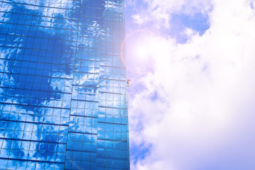 Plakat blue sky and clouds reflected in windows of modern building