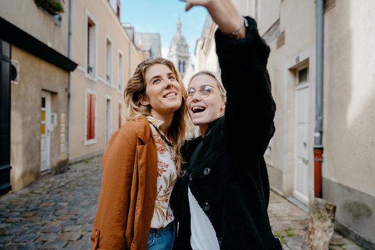 Young women taking selfie in a typical french town's street