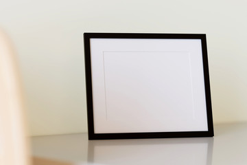 Black picture frame on table. 3d render.
