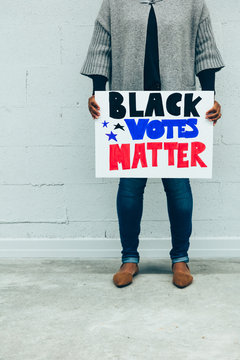 Woman holding Black Votes Matter protest sign