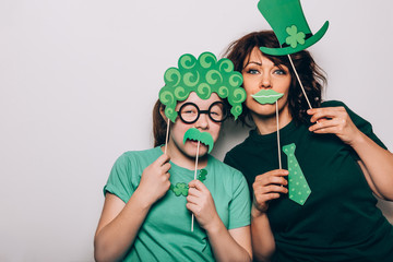 Young girl and a woman are preparing for the St Patricks Day party with photo booth props, Ireland...