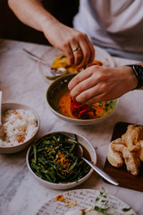 Young man eating in Balinese restaurant 