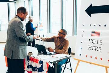 Volunteer helping voters at polling place