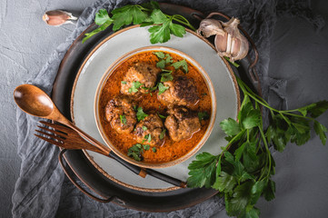 Tasty homemade meatballs with tomato sauce and herbs served in a plate