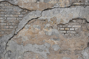background, peeling stucco on an old brick wall with cracks