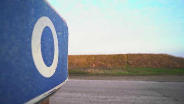 Zero road sign. Zero mile, kilometer. Check Point. Border of two countries. Equator. The beginning of the way. Fence on the cordon. Blue road sign. Traffic Laws. Travels. Tourism. Road for trucker.