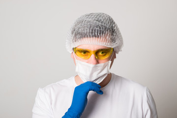 Doctor in a surgical mask, gloves and glasses. Surgeon before the operation. Young man in a medical mask.