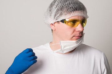 Doctor in a surgical mask, gloves and glasses. Surgeon before the operation. Young man in a medical mask.