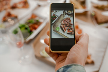 Photo of food for social networks on the phone, junk food, pizza, home delivery food. International friendship, happy time together, friends having relax time. Enjoy communication and holiday.