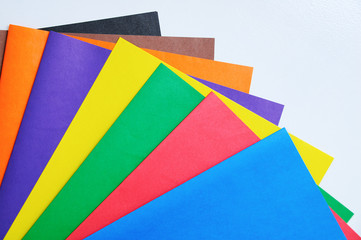 Sheets of colored matte paper on white background. Close-up.