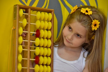 little girl with a wreath on her head and an abacus,