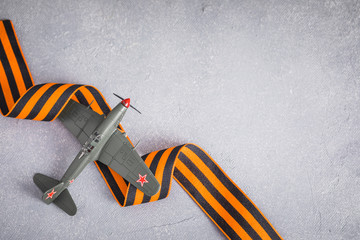 Traditional Saint George ribbon with aircraft model,Victory Day, May 9, selective focus