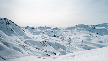 Panoramica de un paisaje montañoso nevado con unas vistas a unas pistas de esquí con telesillas