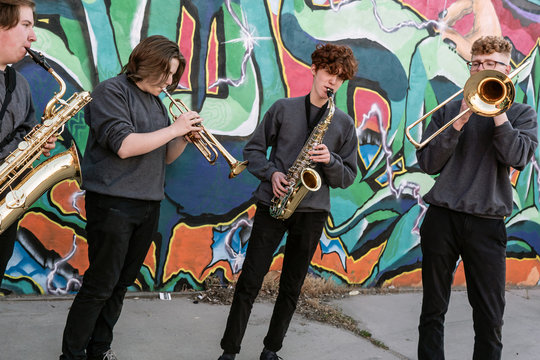 High school jazz band brass musicians by graffiti mural