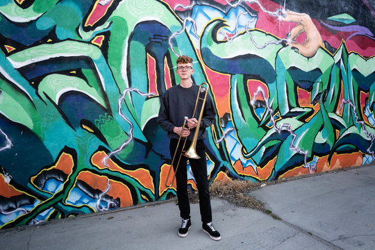 Portrait of high school jazz band trombone player by colorful graffiti