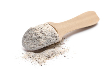 Buckwheat integral flour pile with wooden spoon isolated on white background 