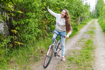 Young woman riding bicycle in summer city park outdoors. Active people. Hipster girl relax and...