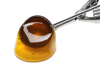 Honey and metal spoon isolated on white background 