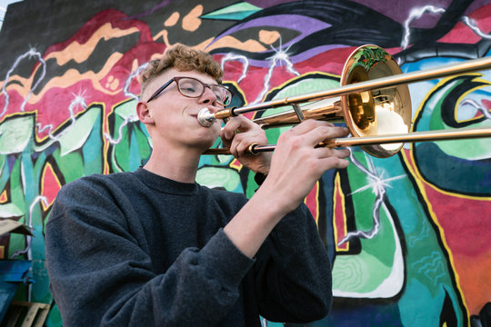 High school jazz band trombone player by colorful graffiti