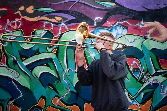 High school jazz band trombone player by colorful graffiti