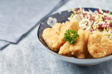 Chicken nuggets with raw salad and french fries on bright wooden background. Copy space.	